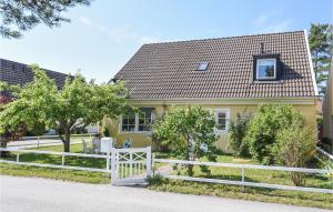 a yellow house with a white fence in front of it at Holiday Home Visby 49 in Visby