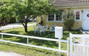 a white fence in front of a house with a table and chairs at Holiday Home Visby 49 in Visby +18 photos