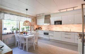 a kitchen with white cabinets and a table and chairs at Holiday Home Visby 49 in Visby