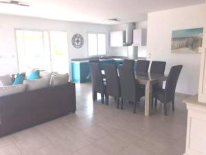 a kitchen and dining room with a table and chairs at Magnifique villa spacieuse 3 chambres tout confort in Sanguinet