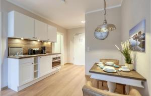 eine Küche mit weißen Schränken und einem Tisch im Zimmer in der Unterkunft Baltischer Hof Apartment 7 in Boltenhagen