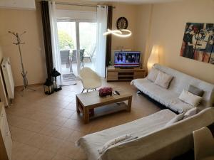 a living room with a couch and a tv at Bella Casa in Nea Peramos