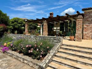 a brick house with a stone retaining wall and flowers at Villa Leopoldo by Istrian Country Houses in Barat