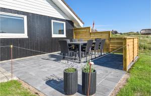 Un patio con una mesa y sillas. en Holiday Home Wolle Friks Vej Ringkøbing Xii, en Søndervig