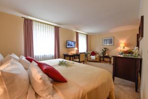 a hotel room with a large bed with red pillows at Atrium Hotel Amadeus in Osterfeld