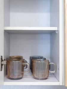dos ollas metálicas en un estante de una cocina en Wellness Stay, en Seúl