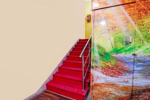 a staircase with red carpeting and a painting on the wall at FabExpress Apple Grand Gandhipuram in Coimbatore