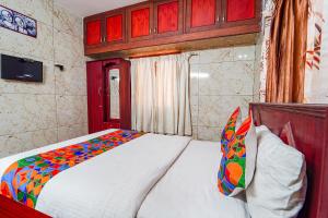 a bedroom with a white bed with a colorful blanket at FabExpress Apple Grand Gandhipuram in Coimbatore