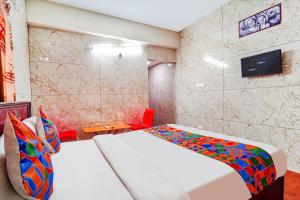 a hotel room with two beds and a tv at FabExpress Apple Grand Gandhipuram in Coimbatore