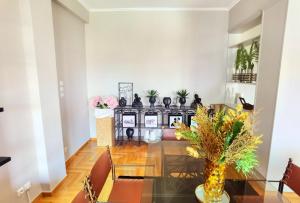 a dining room with a glass table and plants at 110 Sqm 2BR Edem beach luxury apartment in Athens