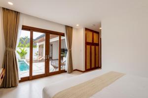 a bedroom with a bed and a balcony at Villa Asri Nusa Dua in Nusa Dua +27 photos