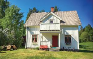 a white house with a red door on a yard at Three-Bedroom Holiday Home In Eksharad in Ekshärad