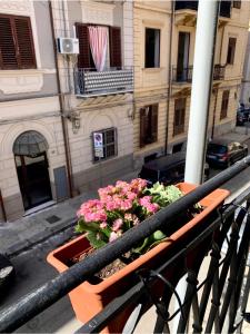 un balcón con flores en una olla sobre una barandilla en Palermo Maison, en Palermo