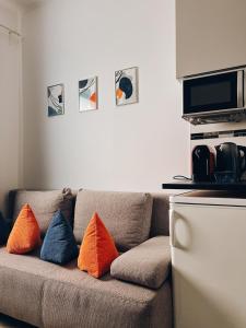a couch with four pillows on it in a living room at Neuwertiges Apartment mit schnellem WLAN, Glasfaser, Kostenlose Privatparkplatz auch für Transporter geeignet R11 in Freiberg am Neckar