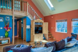 a living room with a blue couch and a loft at Dream Sea Chalet in Yachats