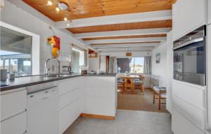 una cucina con armadi bianchi e una sala da pranzo di Holiday Home Fanø 60 a Fanø