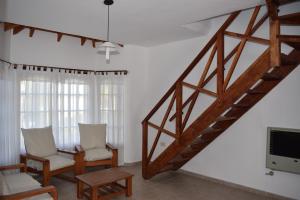 sala de estar con escalera, sillas y TV en Las Rosas, en Costa del Este