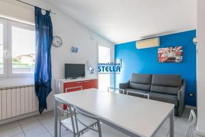 a living room with a table and a couch at Condominio Milan in Lido di Jesolo