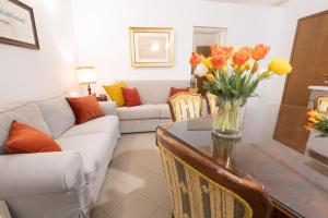 a living room with a vase of flowers on a table at Ca' Spadoni, centro storico, piano terra, ingresso indipendente, teatro, parcheggio, in Imola
