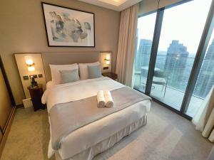 a hotel room with a large bed and a large window at 2BD Luxury Opera District Apt Downtown in Dubai