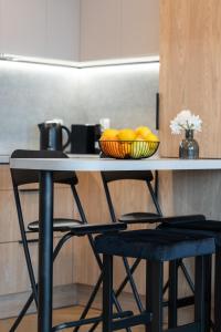 グダニスクにあるGarnizon Apartment Hemara in Gdańsk Wrzeszcz by Noclegi Rentersの椅子2脚とレモンのボウルが置かれたテーブル