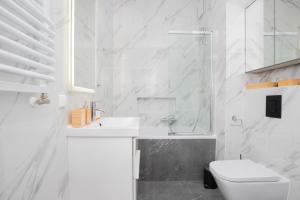 グダニスクにあるGarnizon Apartment Hemara in Gdańsk Wrzeszcz by Noclegi Rentersのトイレと洗面台を備えた白いバスルーム