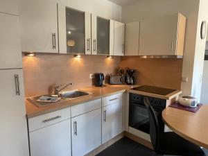 una cucina con mobili bianchi e un lavandino di Fewo 29 Ferienwohnung mit Balkon a Rerik