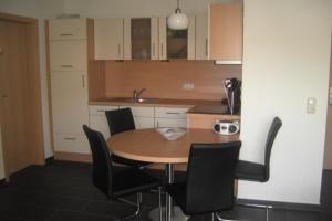 una cucina con un tavolo e sedie in una stanza di Fewo 29 Ferienwohnung mit Balkon a Rerik Altre 3 foto