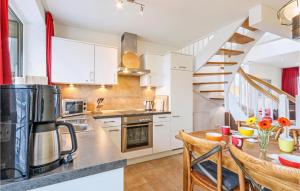 una cucina con mobili bianchi e un tavolo con sedie di Two-Bedroom Apartment In Rechlin a Rechlin