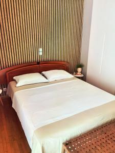 a bedroom with a large white bed with a striped wall at 110 Sqm 2BR Edem beach luxury apartment in Athens