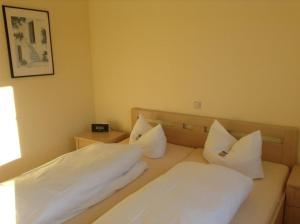 two beds in a hotel room with white pillows at Fewo 202 Ferienwohnung in Strand- und Spielplatznähe in Rerik