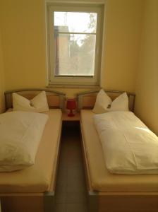 two beds in a small room with a window at Fewo 202 Ferienwohnung in Strand- und Spielplatznähe in Rerik