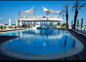 a large swimming pool with a building in the background at Luna Studio White Tower in Mamaia