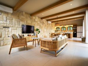 Una sala de estar con un sofá y un televisor. en Luna Ola Villa Berawa, en Canggu