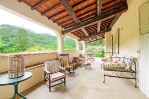 a porch with chairs and a table and a window at La Maison de Raymond - Sublime villa avec piscine in Générargues
