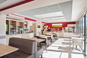 a restaurant with tables and chairs and red walls at Ace Hôtel Paris Sud Villabe in Villabé