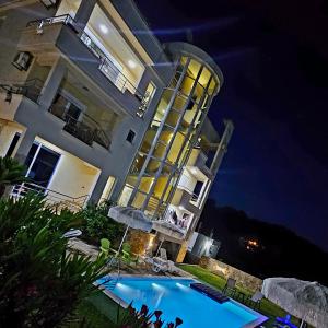 a building with a swimming pool in front of it at night at Kopernikus Apartments in Ulcinj