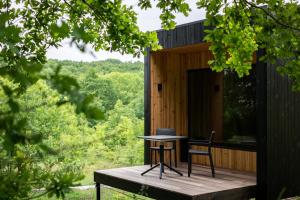 OposhnyaにあるOBRIY holiday villageの木製デッキにテーブルと椅子