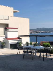 a table and chairs on a balcony with a view of the water at Apartments Ruza in Ražanj