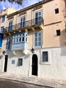 un edificio con porta nera e balcone di Prestigious Pied a Terre Wignacourt with views a La Valletta