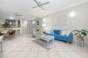 a living room with a blue couch and a table at Breakwater 13 in Townsville