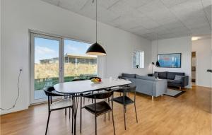 a dining room and living room with a table and chairs at Holiday Home Ringkøbing 47 in Søndervig