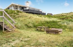 ein Haus auf einem Hügel mit einem Picknicktisch in der Unterkunft Stunning Home In Ringkøbing With Sauna in Ringkøbing + 30 Fotos
