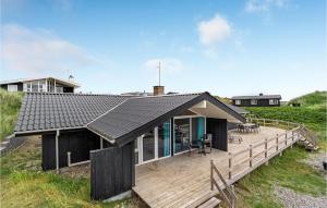 Ein Haus mit einer Holzterrasse und einem Haus in der Unterkunft Stunning Home In Ringkøbing With Sauna in Ringkøbing