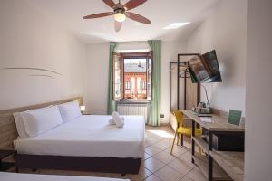 a bedroom with a bed and a desk and a television at LVG Hotel Collection - Tornielli 9 in Novara