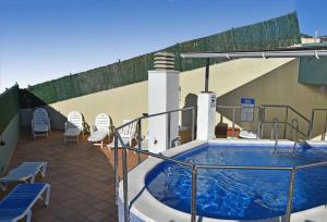 a swimming pool on the roof of a building at Apartamentos AR Dosjoimi in Lloret de Mar