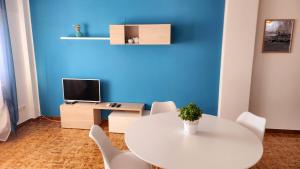 a white table and chairs in a room with a blue wall at Rio Vivo Home in Termoli