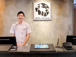 a man standing in front of a reception desk at HOTEL KANALOA in Tokashiki