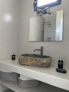 a bathroom with a stone sink and a mirror at Anafi Tholos House in Anafi