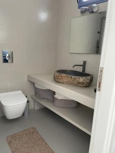 a bathroom with a sink and a toilet at Anafi Tholos House in Anafi +23 photos